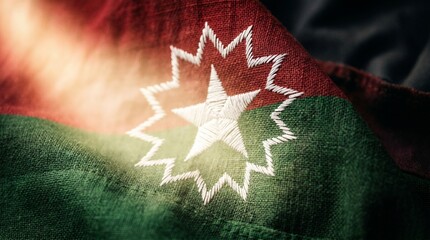 Close up of embroidered star on Juneteenth flag with red, green, and black colors.