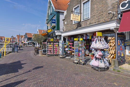Volendam, Netherlands - May 31, 2026: Souvenir shop displaying traditional wooden shoes, bags, and postcards along the harbor dike street.