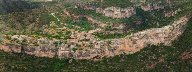 Fototapeta premium Detailed aerial view of Siurana village dramatically perched on a narrow sandstone cliff plateau in Catalonia, Spain.
