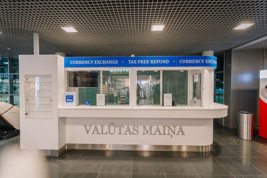 Currency exchange counter with tax-free refund services in a modern airport terminal featuring clear signage and a sleek design