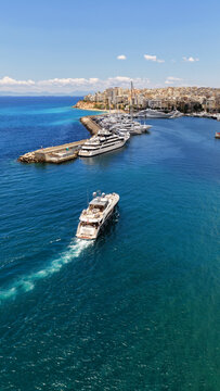 Aerial drone photo of small yacht cruising in low speed near marina and port of Zea or Pasalimani, Piraeus, Attica, Greece