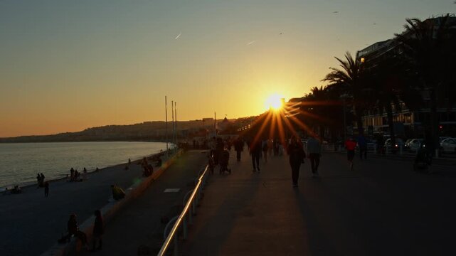4K French Riviera Nice pan on the seaside at sunset with people walking around in slow motion 