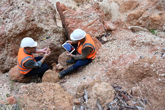 Geologists conducting field inspection and geological survey at an excavation site. Professionals analyzing soil, rock formations and subsurface conditions for mining, construction and exploration pro