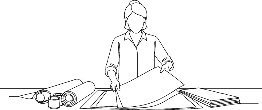 Architectural draftswoman reviewing large blueprints at workstation.