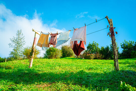 Clothes drying rack and colourful clothes on the green grassy slope