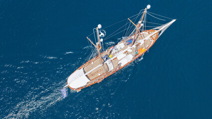 Naklejka premium Aerial drone top down photo of classic wooden double mast sailing ship cruising in open ocean sea
