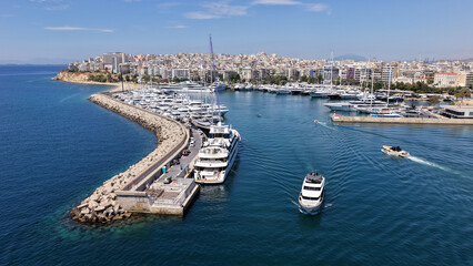 Naklejka premium Aerial drone photo of small yacht cruising in low speed near marina and port of Zea or Pasalimani, Piraeus, Attica, Greece