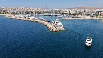 Naklejka premium Aerial drone photo of small yacht cruising in low speed near marina and port of Zea or Pasalimani, Piraeus, Attica, Greece