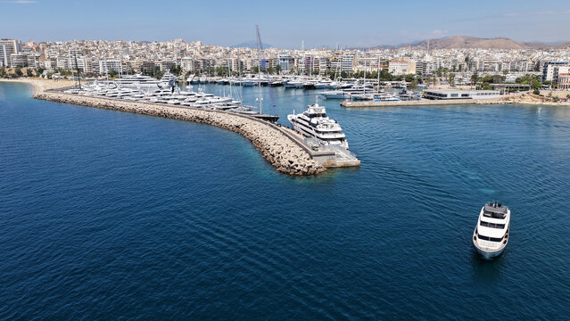 Aerial drone photo of small yacht cruising in low speed near marina and port of Zea or Pasalimani, Piraeus, Attica, Greece