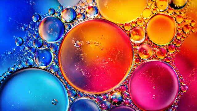 Oil droplets forming colorful bubbles on liquid surface macro