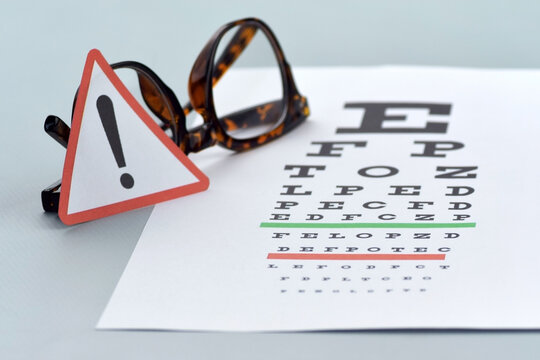 Eye test chart and glasses on blue background