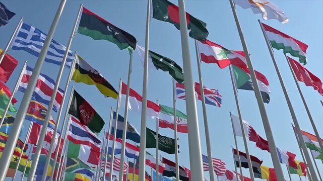International flags waving in clear blue sky, global unity and diplomacy concept, world nations banner display, international relations and multicultural cooperation