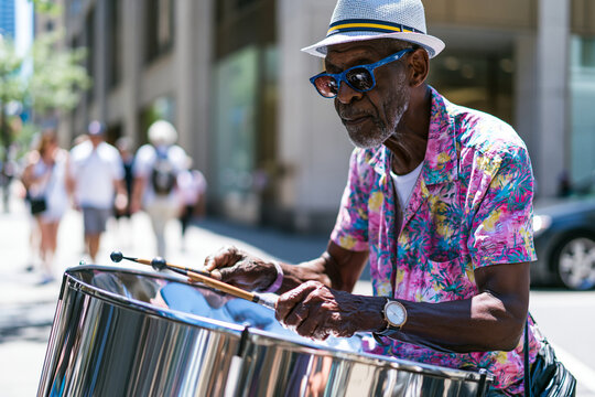 Urban Music Scene: Street Musician Playing Pan Flute and Steel Drum in Vibrant City Life Atmosphere
