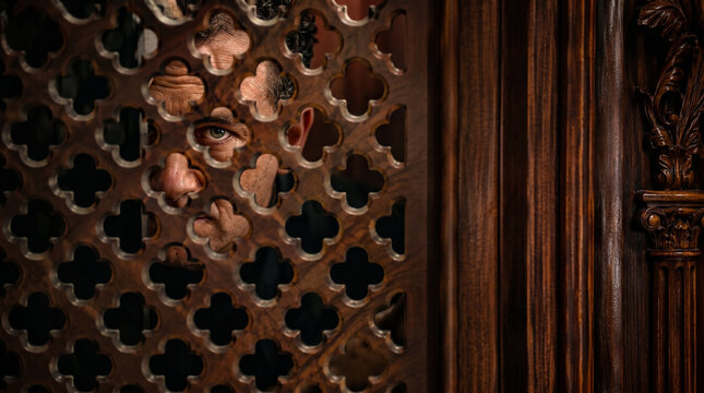 Man's Face Behind Carved Wooden Lattice of Confessional &mdash; Eye Looking Through Ornament