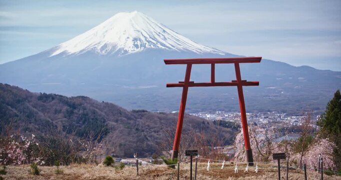 Tall torii gate on hill over Japanese city and distant Mt. fuji - wide, tracking shot