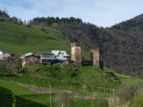 Svaneti historic village with medieval stone towers and blooming spring trees, Georgia.