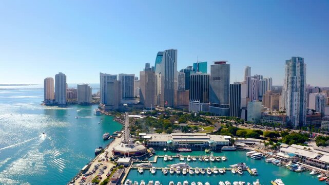 Discovering the Miami skyline from the air over Biscayne Bay with luxury high-rises and vibrant city life under sunny skies