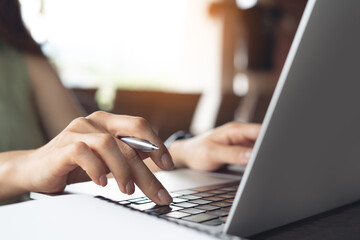 Fototapeta premium Business woman typing, working on laptop on table at home office, close up