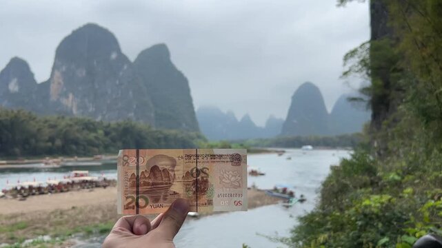 Hand Holding 20 Chinese Yuan Banknote Compare with Real Li River Karst Mountain Scenery, Famous 20 RMB Landscape Yangshuo Guilin China
