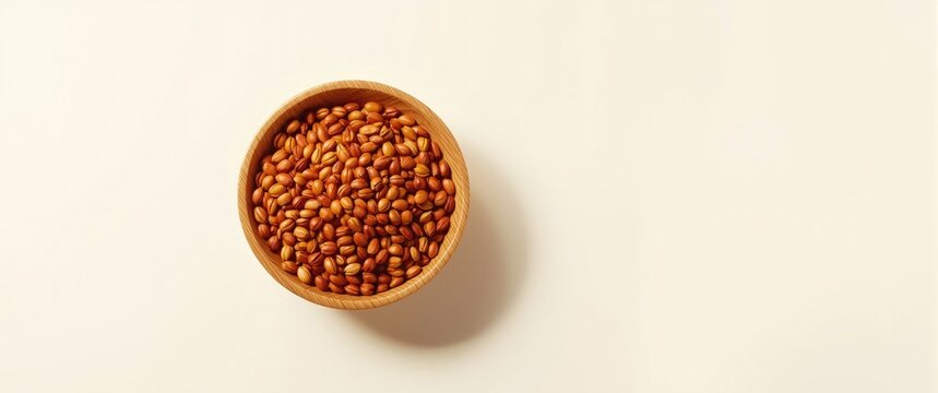 White background emphasizing organic annatto seeds in artisanal wooden bowl
