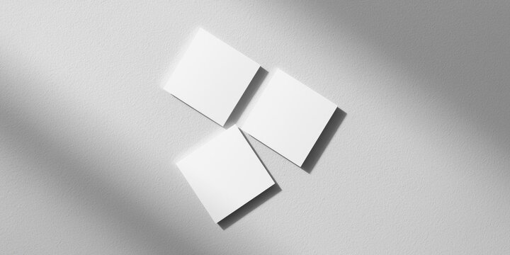 Set of four white square business card mockups casting gentle shadows on a subtle neutral light grey textured background from above