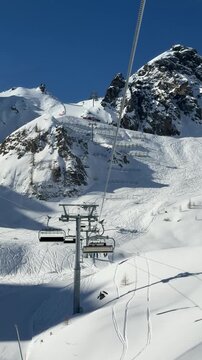 POV view from a chairlift ascending snowy slopes in Livinallongo del Col di Lana, Dolomites. Spectacular alpine scenery, ski runs and winter adventure in the Dolomiti Superski area