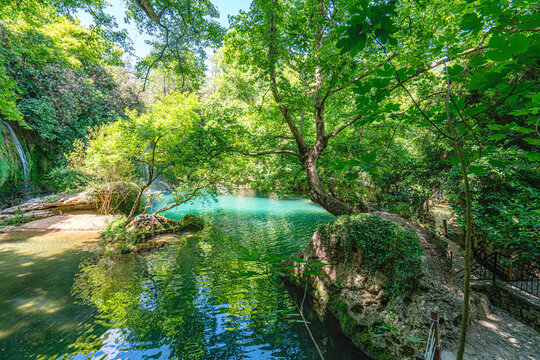 Scenic view of Kursunlu Waterfall and emerald water pond in Antalya nature park, Turkey.
