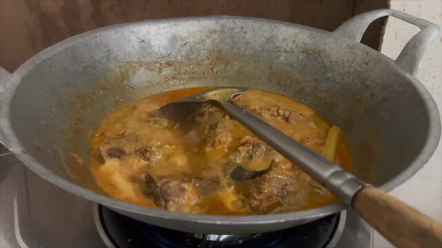 Traditional beef rendang cooking in a wok until thickened