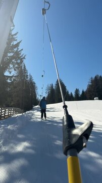 Skier riding a drag lift in Badia, Dolomiti Superski, Italy. Groomed ski slope and alpine scenery in the heart of the Dolomites. Winter sports and skiing adventure in the Italian Alps