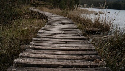 Obraz premium rustic footpath of aged gray wood beside lake