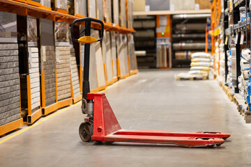 Manual pallet truck standing in warehouse aisle near storage shelves © Владислав Легір