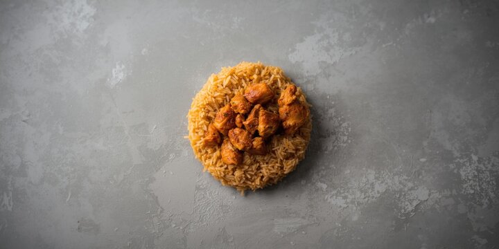 Spiced chicken and rice Kabse served on a muted grey background with copy space
