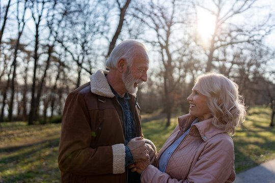 Retired couple enjoying a peaceful moment together outdoors. Ideal concept for retirement planning, financial security, pension savings, long-term stability, and life after work