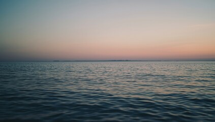 Obraz premium Peaceful water ocean scene during dusk with gentle sky hues and copy space