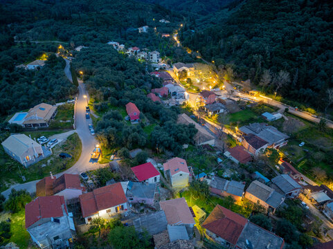 Wide angle aerial drone photo of Nymfes Corfu showcasing the entire village layout against the Pantokrator mountain range