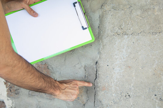 Man checking a cracked wall after earthquake.