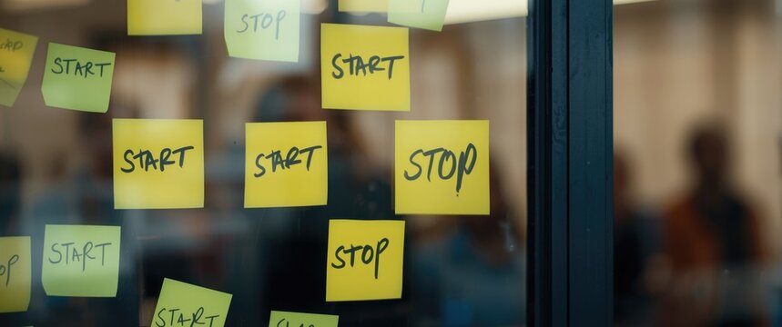 Spanish labeled keep start and stop notes stuck on window with agile team