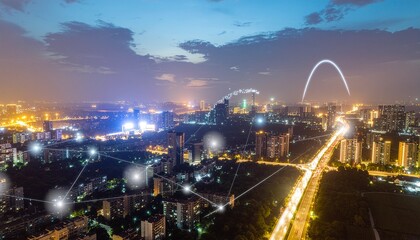 Obraz premium Aerial night view of a city skyline with glowing network nodes and light trails on the highway
