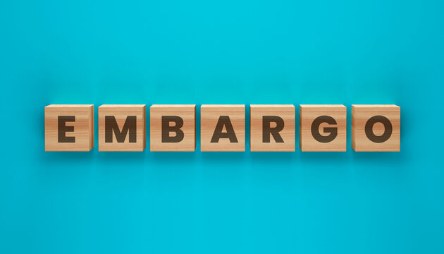 Embargo Message on Wooden Blocks: The word EMBARGO spelled out on individual wooden blocks, set against a vibrant teal background, conveying a message of restriction or prohibition.