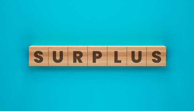 Surplus spelled out on Wooden Blocks: The word SURPLUS is spelled out using individual wooden blocks, each featuring a single letter, set against a vibrant teal background.