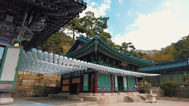 Beautiful traditional Korean Buddhist temple with colorful hanging paper lanterns under a blue sky