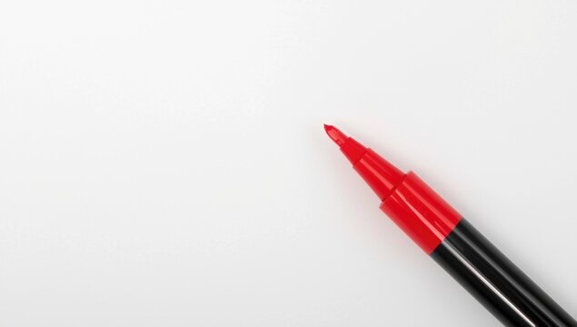 Single red marker positioned near white paper background with copy space