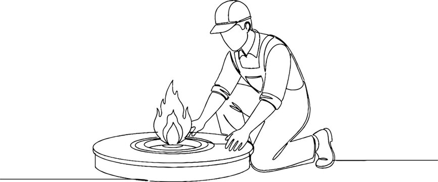 Industrial worker handling fire in large metal container.