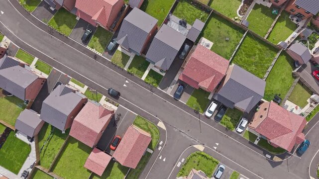 Aerial view, new build housing estate, residential houses along street with parked cars, England