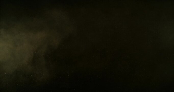 Ultra slow motion dust or sand cloud drifting through the air on a black background. Particle explosion effect ideal for overlays, compositing, visual effects, motion graphics and VFX projects.