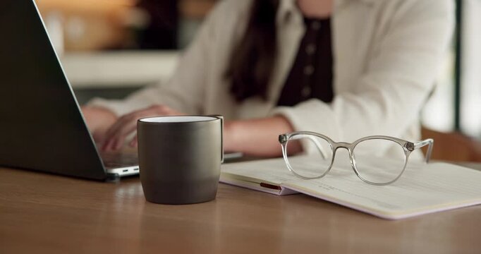 Student, hands and typing in home with laptop, glasses and notebook for distance learning university. Woman, research and study in house with computer, coffee or online education for college project.