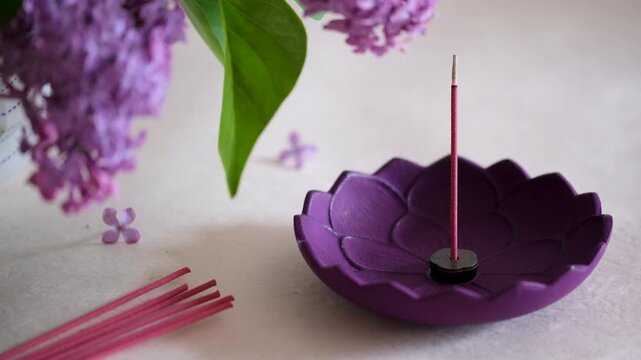 Burning Japanese Incense Stick in Holder with Lilac Flowers, Zen Relaxation Scene, Timelapse