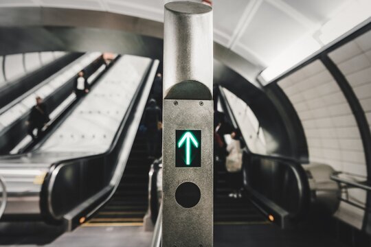 Green up arrow in front of escalators