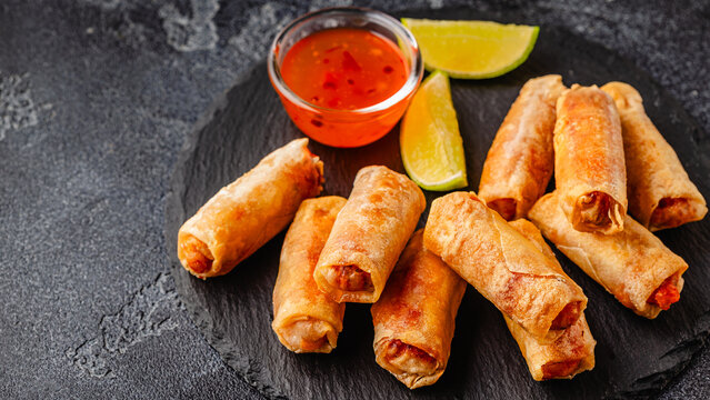 Fried spring rolls served with sauce and lime