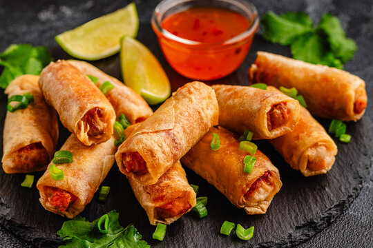 Fried spring rolls served with sauce and lime
